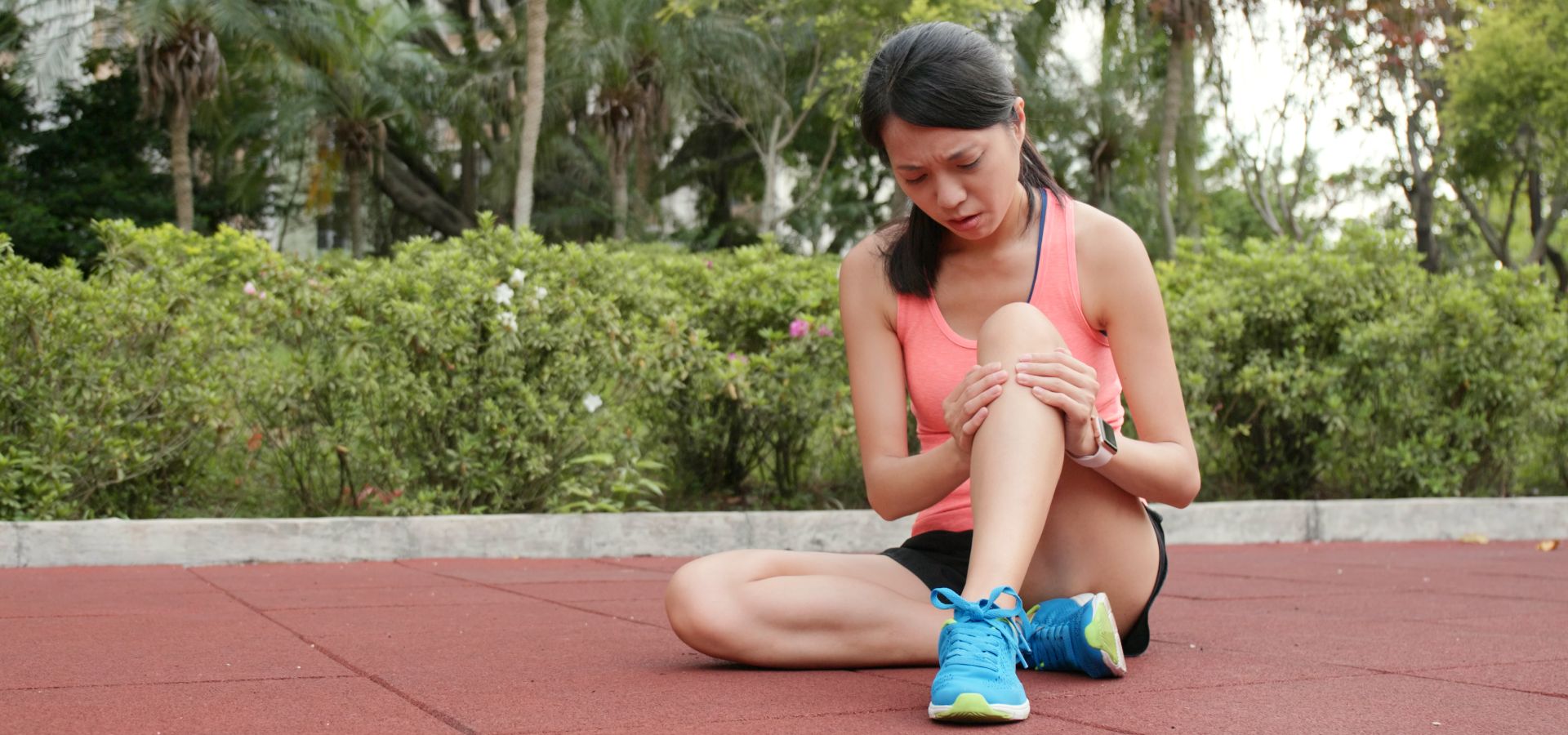 Photo of a female runner on the ground, holding her knee in pain. Get joint pain treatment with Advanced Pain Medical.